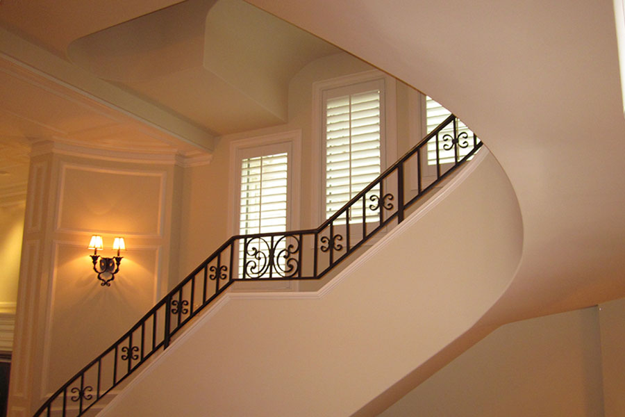 Polywood shutters on three windows in an ornate stairwell