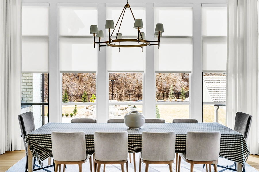 Custom window shades and drapery in a formal dining area with large vertical windows
