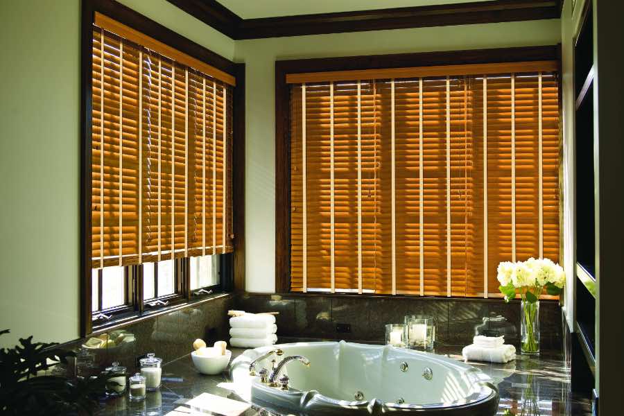 Premium quality blinds are always a stylish accent in your Orlando home. Brown wood blinds on large windows in a green bathroom