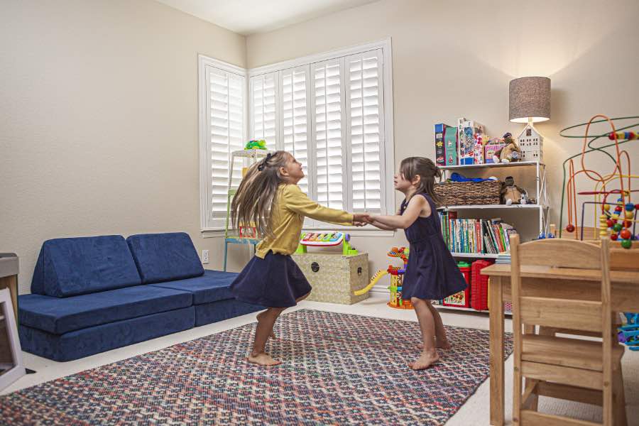 Choose Polywood shutters for durable, kid-friendly great room window treatments in Orlando. Polywood shutters on multiple windows in a sitting area