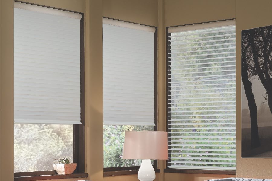 Opaque motorized window shades in Orlando keep hot UV rays out of your home. Gray motorized sheer shades on corner windows next to gray furniture