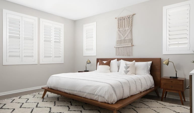 Open shutter louvers will help any Orlando room feel larger. Plantation shutters in a model home bedroom.