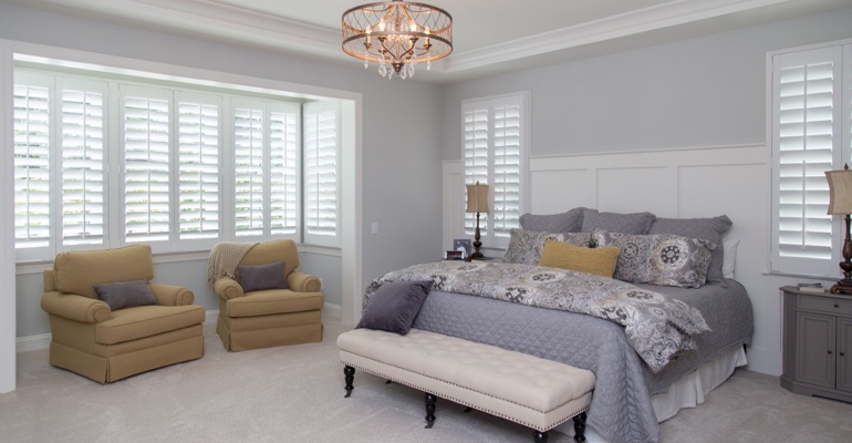 interior shutters offer subtle fashion. White shutters in Orlando bedroom.