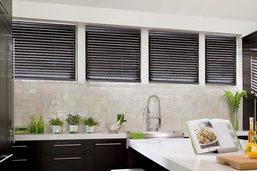 Choose custom Polywood faux wood blinds for your kitchen in Orlando. Special shaped faux wood blinds in several windows above a sink.