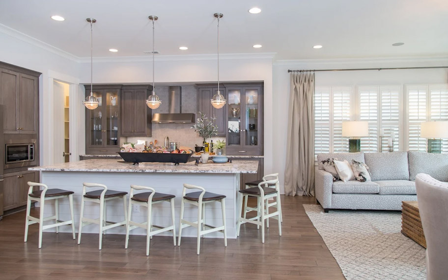 Illuminate your home with custom interior shutters in Orlando. White arched shutters in a white kitchen with lots of light.