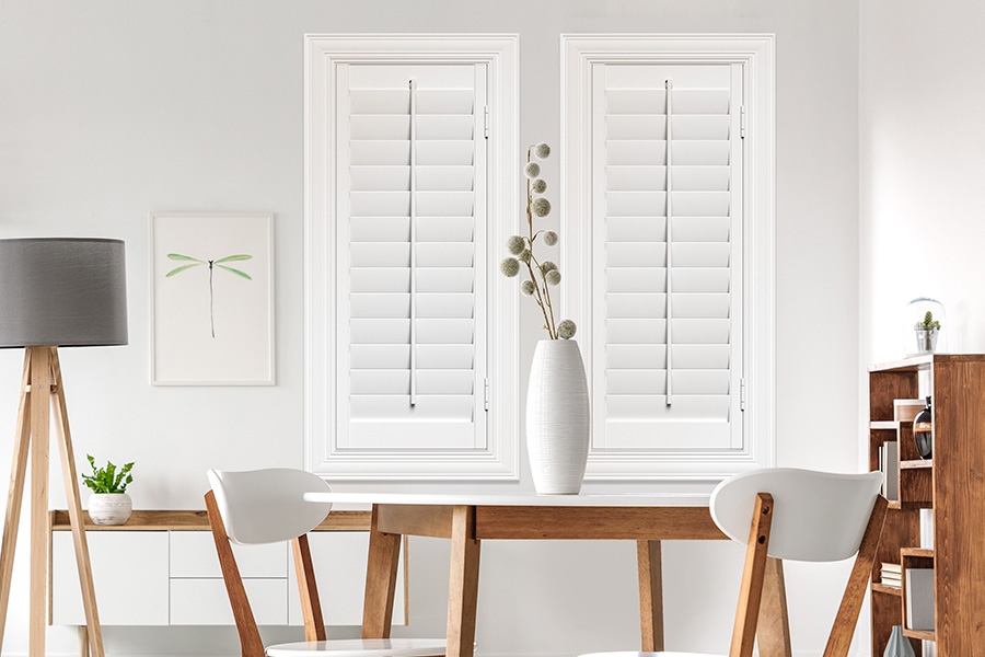 Sunburst's selection of stylish window treatments for designers in Orlando makes it easy to find the perfect ones for every design job.  White Polywood shutters on two windows in a modern Scandinavian-style room