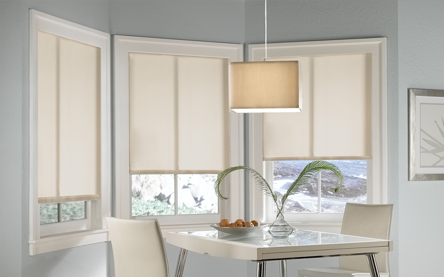 Quality window shades meet modern interior design at Sunburst Shutters Orlando. Roller shades in modern white kitchen.