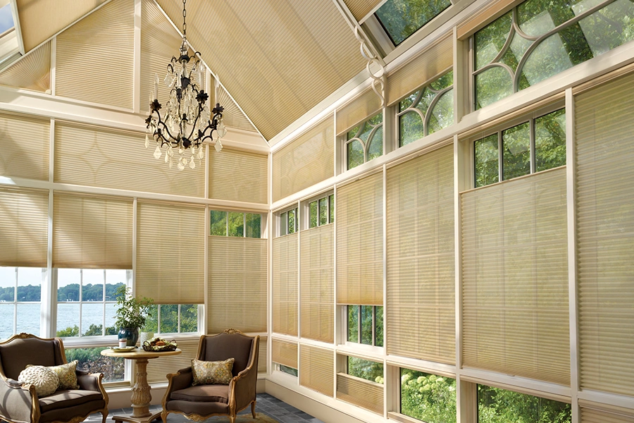 Tan window shades on windows and skylights in a large sunroom